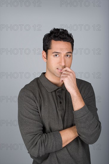 Studio shot portrait of mid adult man with finger on lips, waist up. Photo : Rob Lewine