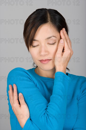 Studio shot of Vietnamese woman day dreaming. Photo : Rob Lewine