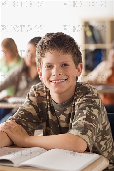 Happy schoolboy sitting in classroom. Photo : Rob Lewine