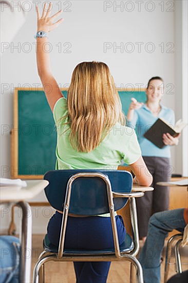 Girl rising hand in classroom. Photo : Rob Lewine