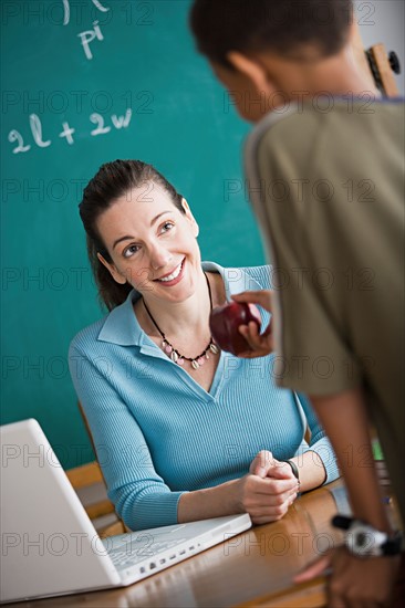 Boy attempting to bribe teacher with apple. Photo : Rob Lewine