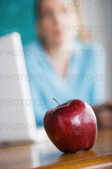 Woman with apple and laptop. Photo : Rob Lewine