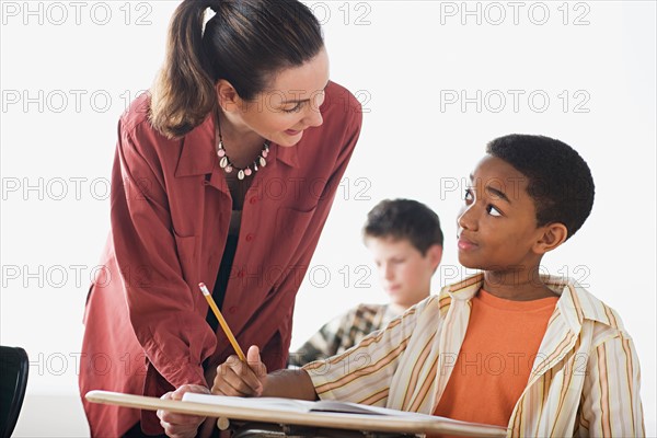 Teacher checking boys homework. Photo : Rob Lewine