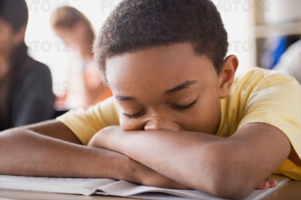 Bored schoolboy sleeping on desk. Photo : Rob Lewine