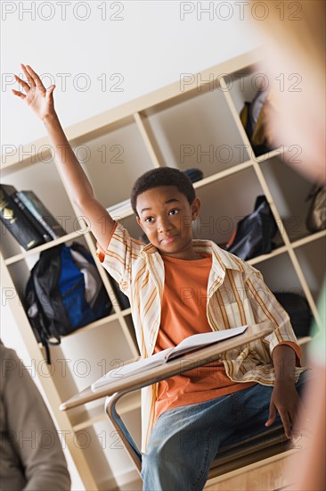 Boy rising hand in classroom. Photo : Rob Lewine