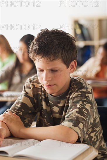 Serious schoolboy sitting in classroom. Photo : Rob Lewine