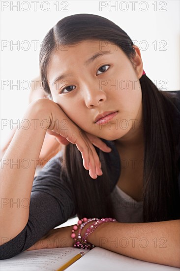 Bored schoolgirl leaning on desk. Photo : Rob Lewine