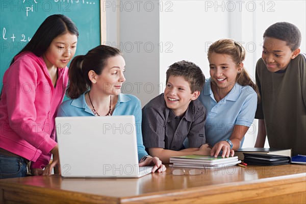 Group of school children with teacher using laptop . Photo : Rob Lewine