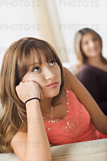 Angry daughter sitting with mother on sofa. Photo : Rob Lewine