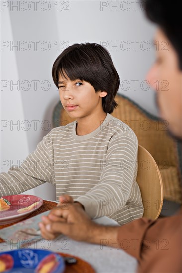 Son looking at father during prayer before meal. Photo : Rob Lewine