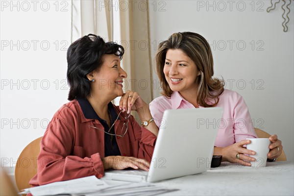 Senior women using laptop at home. Photo : Rob Lewine