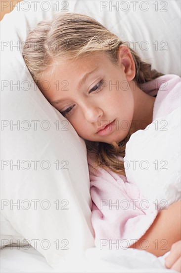 Portrait of girl laying in bed. Photo : Rob Lewine