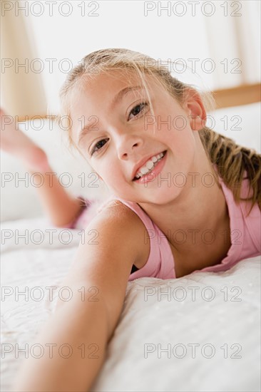 Portrait of girl lying on bed. Photo : Rob Lewine