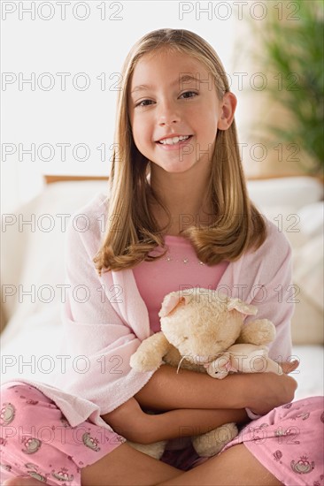 Smiling girl (12-13) holding teddy bear. Photo : Rob Lewine