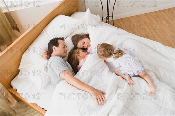 Family with two daughters (8-9, 12-13) in bed. Photo : Rob Lewine