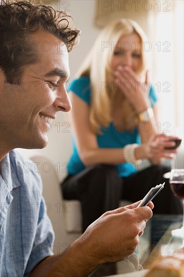 Couples on sofa at home party playing cards. Photo : Rob Lewine