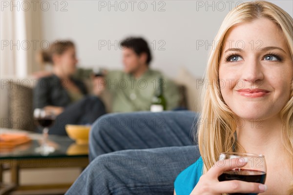 Portrait of smiling woman with couple in background. Photo : Rob Lewine