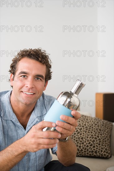 Portrait of smiling man holding cocktail shaker. Photo : Rob Lewine