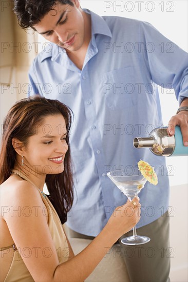 man pouring cocktail into woman's glass. Photo : Rob Lewine