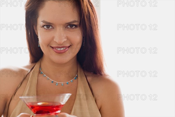 Portrait of smiling mid adult woman holding cocktail. Photo : Rob Lewine