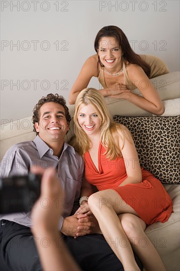 Smiling friends posing together at sofa. Photo : Rob Lewine