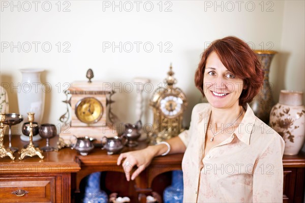 Smiling woman with her collection of antiques. Photo :  Elena Elisseeva