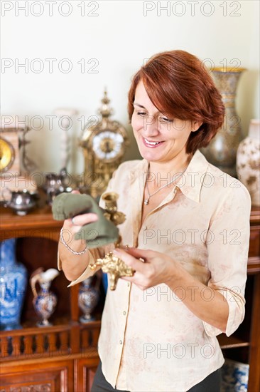 Smiling woman holding old candlestick . Photo :  Elena Elisseeva