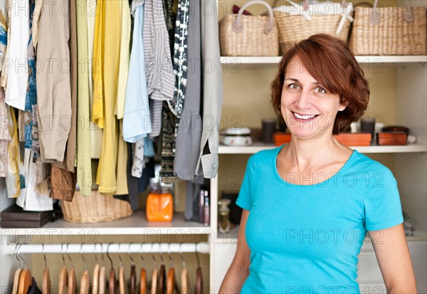 Portrait of woman in front of organized wardrobe. Photo :  Elena Elisseeva