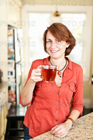 Woman drinking tea in kitchen. Photo : Elena Elisseeva