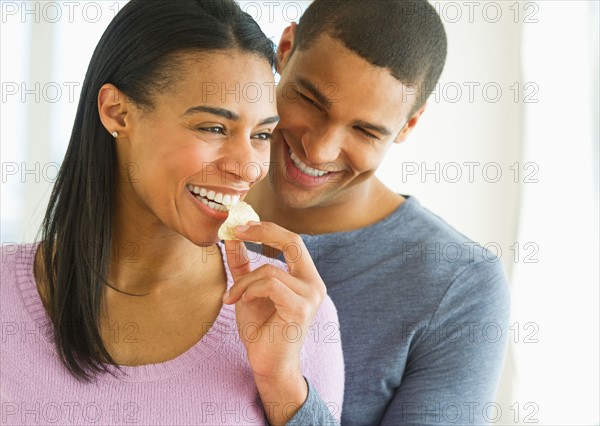 Couple eating potato chips.