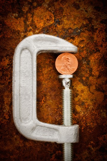 Studio shot of coin in vise grip.