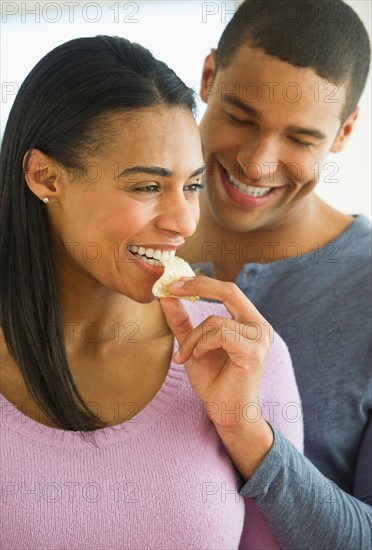 Couple eating potato chips.