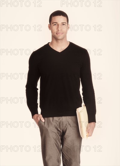 Studio portrait of man holding folders.