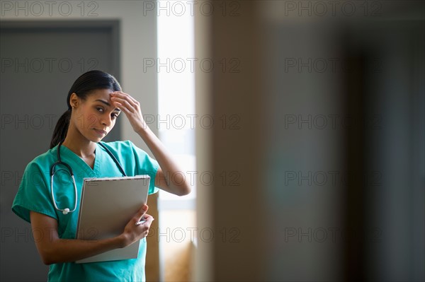 Female nurse with head in hands.