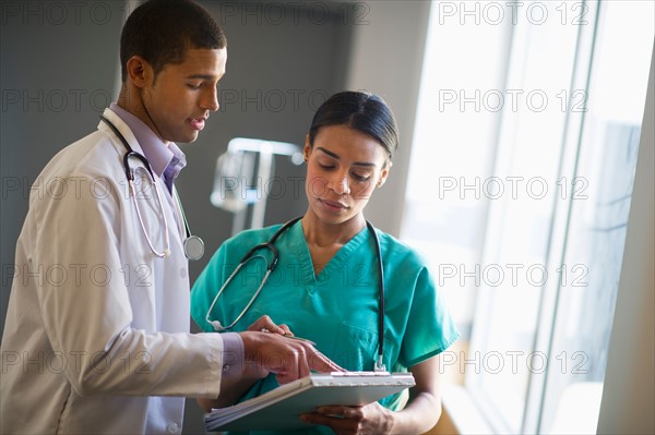 Doctor and nurse talking in hallway.