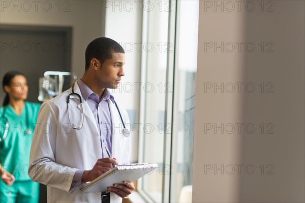 Doctor looking through window.