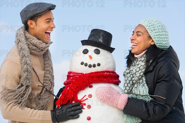 Portrait of couple with snowman.