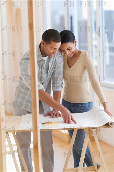 Couple looking at house blueprints.