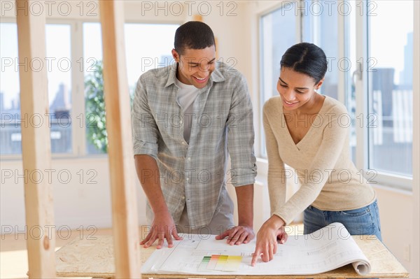 Couple looking at house blueprints.