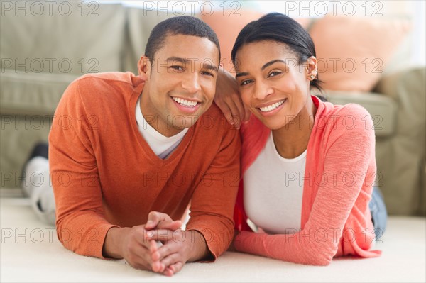 Portrait of couple lying on floor.