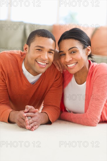 Portrait of couple lying on floor.