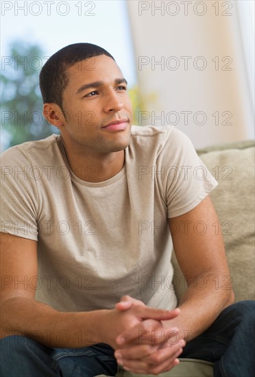 Portrait of man sitting on sofa.