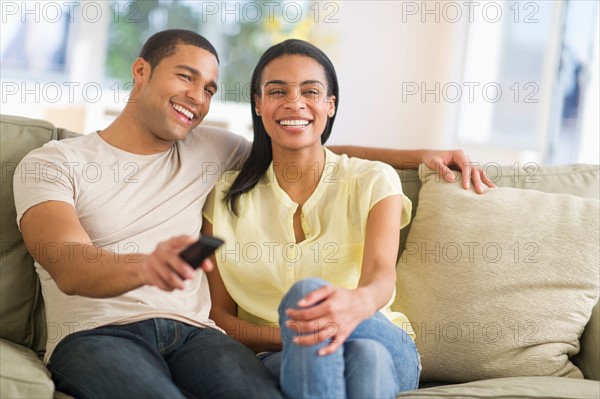 Couple watching tv at home.