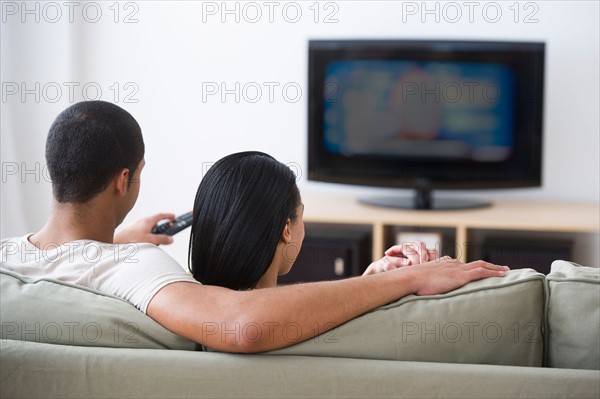 Couple watching tv at home.