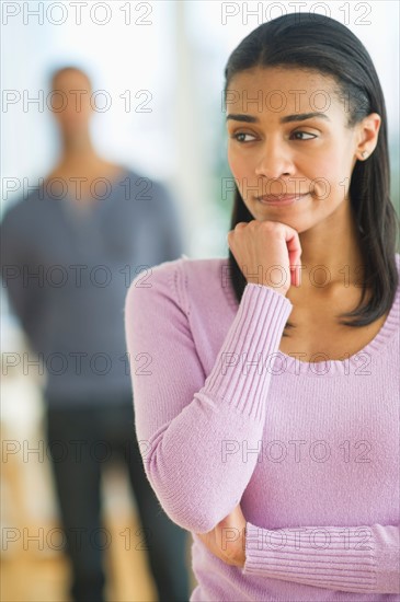 Portrait of woman, man in background.