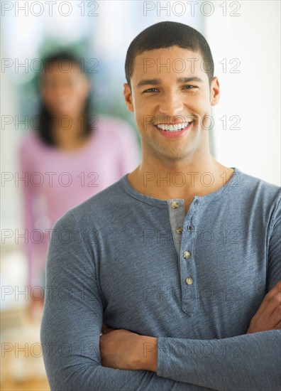 Portrait of man smiling, woman in background.