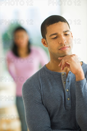 Portrait of man, woman in background.