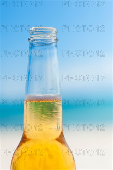 Beer bottle on beach.