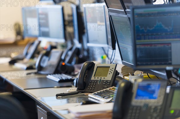 Trading desk with computers and phones.