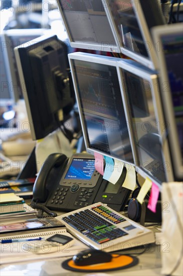 Trading desk with computers and phones.